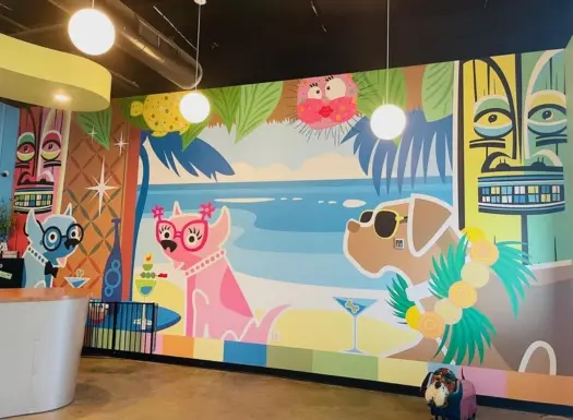 Dog day care lobby with a custom mural of illustrated dogs at a tiki bar on the beach