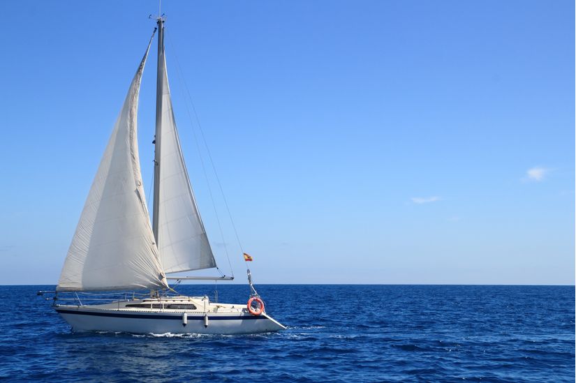 white-sailboat-rides-the-waves-of-the-Mediterranean-sea-on-a-clear-and-sunny-day-