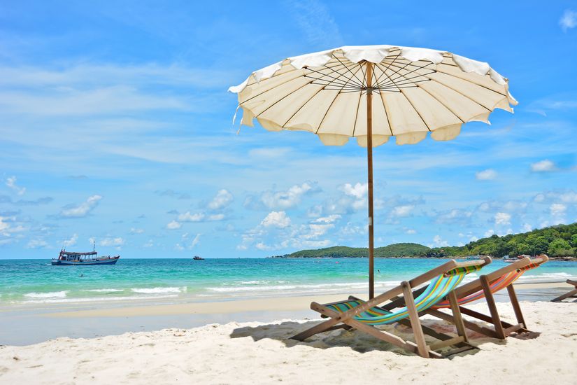 Two Chairs In The Sand Under Umbrella On Beach Stock Photo