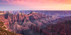 Panoramic-grand-canyon-horizon-landscape-at-sunset-or-sunrise-with-purple-and-pink-rock-formations