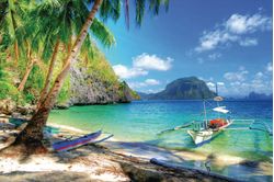 beautiful beach scenery featuring a mountain, palm trees, sailboats, rocks, and shore solitudes in the background