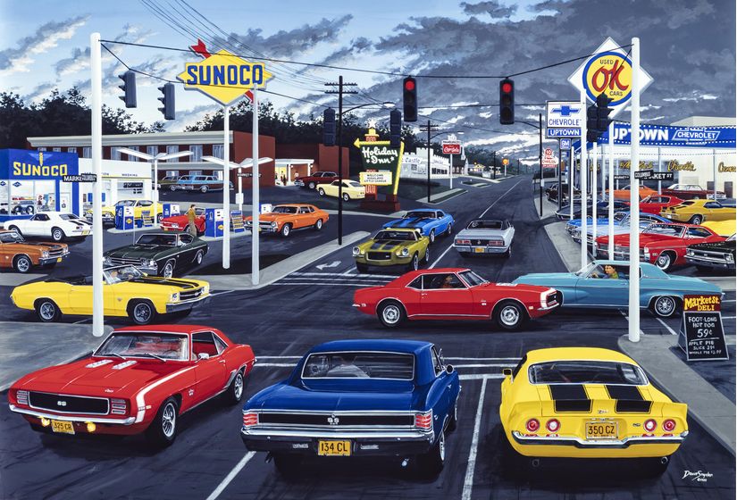 Street-scene-of-classic-Chevy-cars-driving-by-gas-station-chevy-dealership-and-Holiday-Inn-hotel