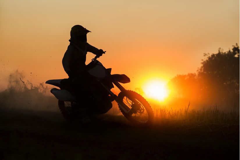 a-silhouette-of-a-motocross-rider-driving-at-sunset