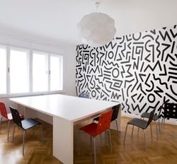 A-modern-conference-room-with-white-table--chairs-light-and-black-and-white-squiggle-mural