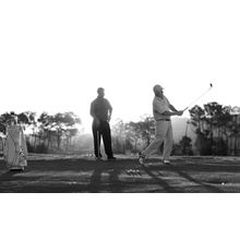 Men Hitting Golf Balls At Sunset Wall Mural