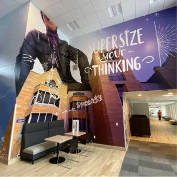 Wall graphics of a university showcasing the buildings and students