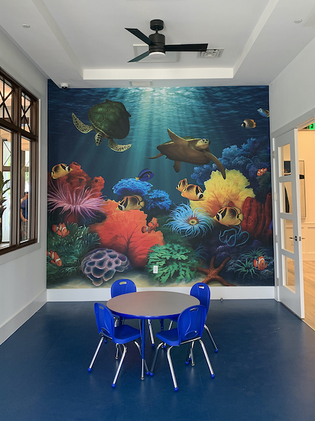 Pediatric waiting room with kids table and sea turtle coral reef wall mural