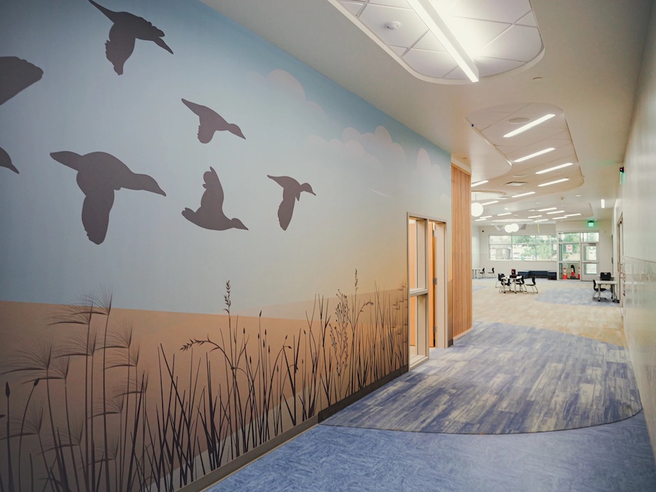 Custom mural of birds flying in a long hallway