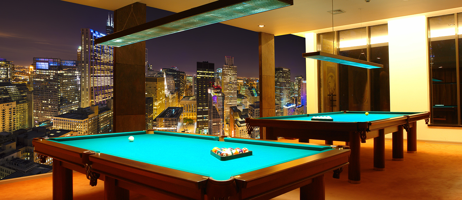 Hotel game room with pool tables and a mural of downtown Chicago at night