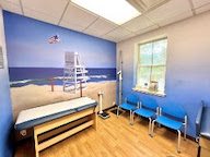 A wall mural of a white lifeguard chair on a sandy beach in a doctor's office