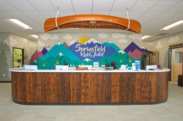 Photo Of Reception Desk With Canoe Above And Cartoon Mountain Mural With Company Logo
