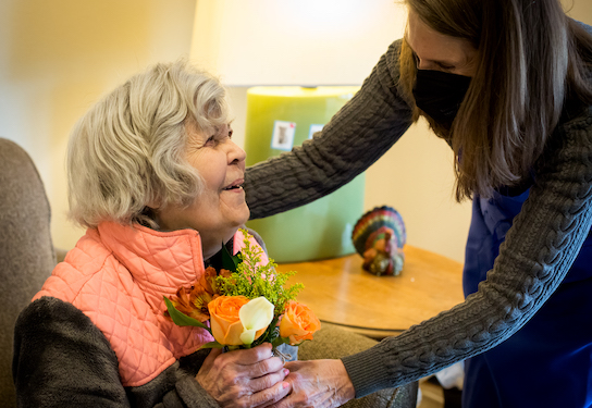 A female delivers flowers to another woman