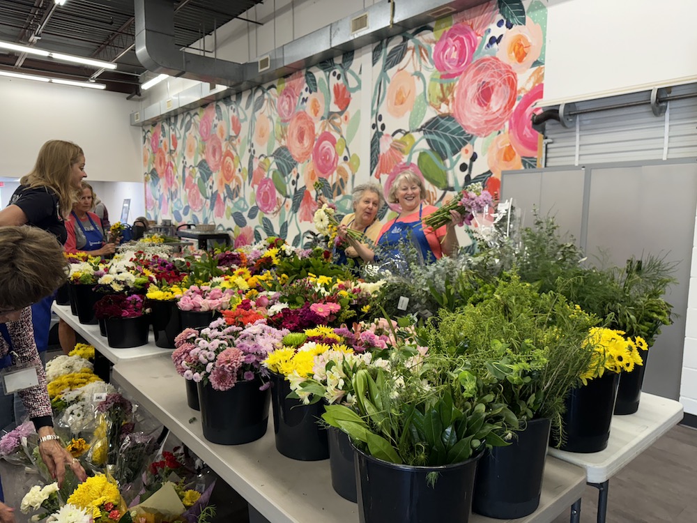 Two women and a room full of flowers after mural installtion