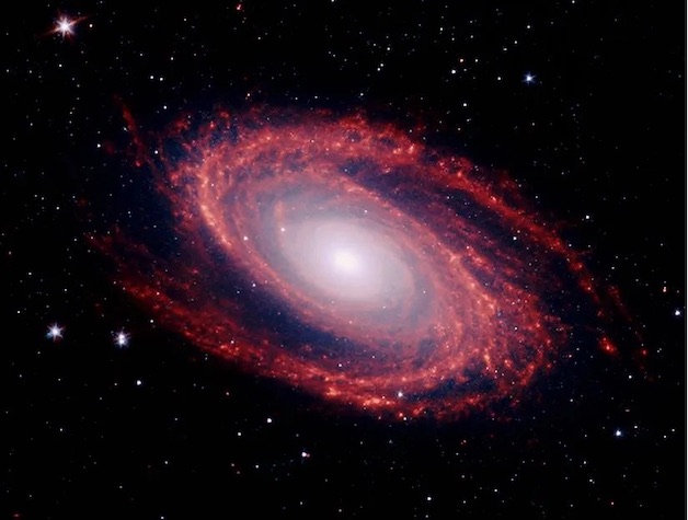 Red colored spiral galaxy against the black starry night of the universe