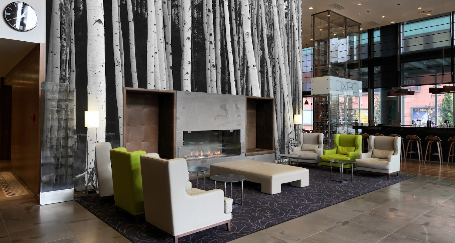 Mural of aspen trunks surrounding a fireplace in a hotel lobby