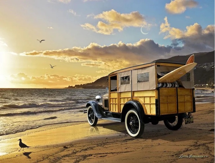 A yellow vintage woodie wagon with a surfboard sits facing the sunset on a beach