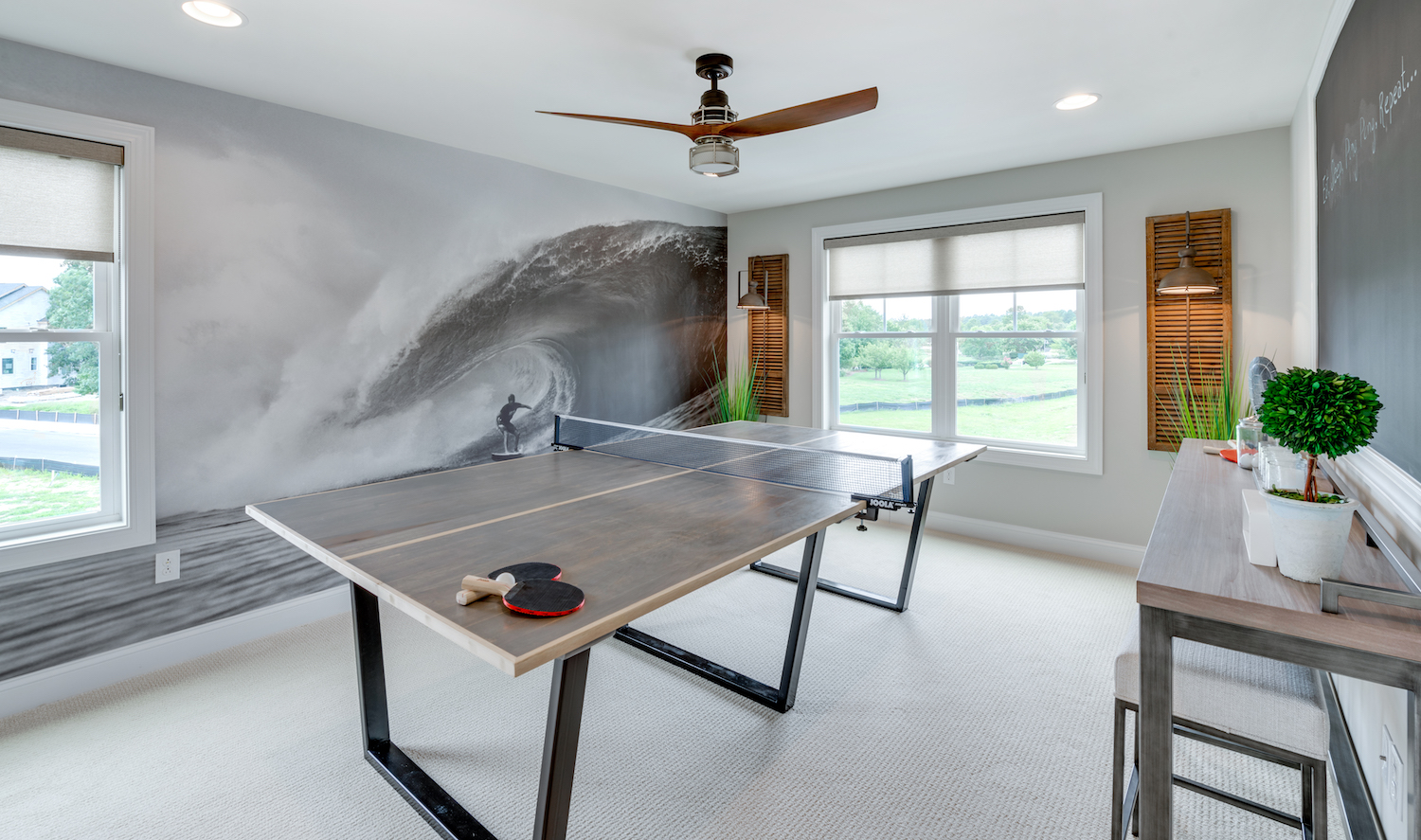 Black and white mural of a surfer on a huge wave in a game room