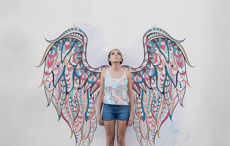 photo of woman in front of patterned wings wallpaper mural